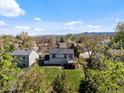 Aerial view of home with a large, well-maintained backyard and mountain views in the distance at 10895 W Bowles Pl, Littleton, CO 80127