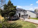 Attractive two-story home featuring stone accents, lush lawn, and an attached two-car garage at 10895 W Bowles Pl, Littleton, CO 80127