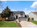 Attractive two-story home with stone accents, a two-car garage, and a lush green lawn at 10895 W Bowles Pl, Littleton, CO 80127