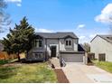 Inviting two-story home with grey siding, stone accents, and an attached two-car garage at 10895 W Bowles Pl, Littleton, CO 80127