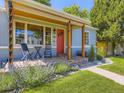 Close-up view of the front porch with brick steps, a red door and decorative landscaping at 1350 E Amherst Ave, Englewood, CO 80113