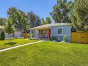Quaint blue home with well-manicured lawn, fenced yard, cozy porch and vibrant landscaping at 1350 E Amherst Ave, Englewood, CO 80113