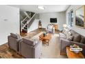 Staged living room featuring gray sofas, chairs, and a wooden coffee table on a soft rug at 3061 W 92Nd Ave # 11B, Westminster, CO 80031