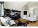 Cozy living room with wood floors, large bookshelf, and comfortable seating area with lots of natural light at 15389 E 99Th Way, Commerce City, CO 80022