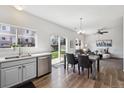 Bright dining area flows to the living room with hardwood floors and sliding glass doors to the yard at 16006 E 97Th Pl, Commerce City, CO 80022