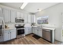 Charming kitchen featuring stainless steel appliances, white countertops and light blue cabinets at 16006 E 97Th Pl, Commerce City, CO 80022