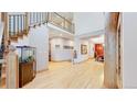 Open foyer featuring hardwood floors, a grand staircase, and a fish tank at 974 Spring Ranch Dr, Golden, CO 80401