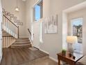 Bright and spacious entryway with hardwood floors, staircase, and ample natural light at 89 Dawn Heath Cir, Littleton, CO 80127