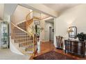 Elegant foyer with a curved staircase, hardwood floors, and neutral decor at 15962 W 70Th Dr, Arvada, CO 80007