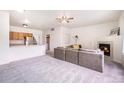 Spacious living room with a fireplace, ceiling fan, and view to the kitchen area at 18038 Becket Dr, Parker, CO 80134