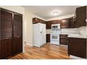 Traditional kitchen with wooden cabinets, laminate flooring, and white appliances at 350 S Clinton St # 2A, Denver, CO 80247
