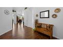 Bright entryway with shiny hardwood floors, white walls, and wood bench with colorful pillows at 3748 Starry Night Loop, Castle Rock, CO 80109