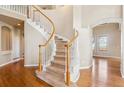 Elegant foyer features a curved staircase with white railings and hardwood floors at 9362 S Holland Way, Littleton, CO 80127