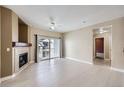 Bright living room with fireplace, white floors, ceiling fan, and a sliding glass door to balcony at 4451 S Ammons St # 1-304, Littleton, CO 80123