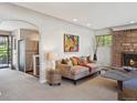 Cozy living room featuring neutral colors, a stone fireplace, and view to kitchen at 1196 S Quebec Way, Denver, CO 80231