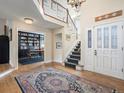 Spacious foyer featuring hardwood floors, a staircase, and an adjacent study with built-in bookshelves at 3 Winged Foot Way, Littleton, CO 80123