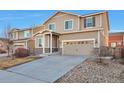 Two-story house with a beige exterior, two-car garage, and a landscaped yard at 9553 Cherry Ln, Thornton, CO 80229