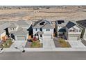 Aerial view of homes showcasing well-maintained lawns, driveways and solar panels on the roof at 244 Chipeta Way, Lochbuie, CO 80603