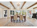 Bright dining room featuring wood beams, a view of the outdoors and stylish furniture on an area rug at 31 Wild Tiger Ln, Boulder, CO 80302