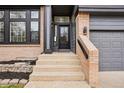 Inviting front entrance with brick accents, gray siding, and a well-maintained walkway at 1057 English Sparrow Trl, Highlands Ranch, CO 80129