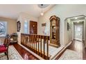 Welcoming foyer with a wooden staircase, a tall grandfather clock, and hardwood floors at 6376 S Pierson St, Littleton, CO 80127