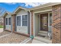 Inviting front porch with brick accents, steps to the front door, and rock landscaping at 6376 S Pierson St, Littleton, CO 80127