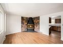 Bright living room featuring hardwood floors and a unique stone fireplace at 6413 W 76Th Ave, Arvada, CO 80003