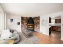 Inviting living room with a striking stone fireplace, hardwood floors, and abundant natural light at 6413 W 76Th Ave, Arvada, CO 80003