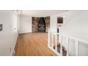 Spacious living room with hardwood floors, a stone fireplace, and staircase at 6413 W 76Th Ave, Arvada, CO 80003