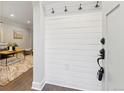 View of the entryway featuring shiplap wall with coat hooks and access to the living room at 1591 Holly St, Denver, CO 80220