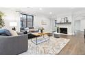 Bright living room with fireplace, neutral decor, large windows, and hardwood floors at 1591 Holly St, Denver, CO 80220