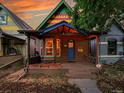 Charming multi-colored single-story home featuring a cozy front porch, a colorful bench, and vibrant curb appeal at 1256 S Pennsylvania St, Denver, CO 80210