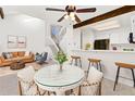 Open dining area with bar seating adjacent to a cozy living space and bright natural light at 14099 E Radcliff Cir, Aurora, CO 80015