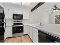 Clean kitchen with white cabinetry and appliances, complemented by wood-look flooring for a modern touch at 14099 E Radcliff Cir, Aurora, CO 80015