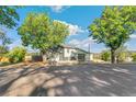 Well-maintained home featuring an attached garage, a spacious yard, and a backdrop of lush greenery at 5385 W 51St Ave, Denver, CO 80212