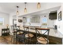 Eat-in kitchen featuring granite countertops, stainless steel appliances, stylish pendant lights, and bar stool seating at 5385 W 51St Ave, Denver, CO 80212