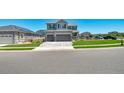 Two-story home featuring a three-car garage, landscaped yard, and a well-maintained lawn at 9716 Uravan St, Commerce City, CO 80022
