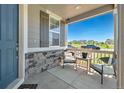 Charming covered front porch with stone accents, seating, and a view of the neighborhood at 9716 Uravan St, Commerce City, CO 80022