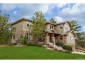 Attractive two-story home featuring stone accents, a manicured lawn, and a two-car garage at 20166 E Shady Ridge Rd, Parker, CO 80134