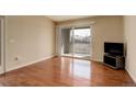 Bright living room with hardwood floors, sliding glass doors to a balcony, and neutral paint at 1120 Opal St # 203, Broomfield, CO 80020
