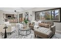 Inviting living room featuring a large window, stylish furniture, and access to the kitchen at 5716 S Lisbon Way, Centennial, CO 80015