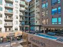 View of a modern apartment building with pool, retail stores, and glass balcony railings at 20 Wilcox St # 517, Castle Rock, CO 80104