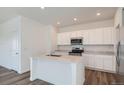 Bright kitchen featuring white cabinets, stainless steel appliances, and a center island with a sink for modern convenience at 15238 Detroit St, Thornton, CO 80602