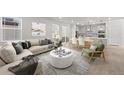 Bright, open-concept living area with modern decor, neutral tones, and seamless flow to dining and kitchen at 7310 Watercress Dr, Littleton, CO 80125