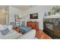 Inviting living room featuring a fireplace, TV, bookcase, and comfortable furniture at 5677 S Park Pl # B110, Greenwood Village, CO 80111