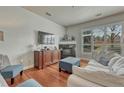 Cozy living room features a fireplace, built-in cabinet, and oversized window providing abundant natural light at 5677 S Park Pl # B110, Greenwood Village, CO 80111