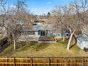 Aerial view of the home's backyard with a well-kept lawn, patio, deck, and fencing at 6252 W 70Th Pl, Arvada, CO 80003