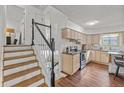 Traditional kitchen with stainless steel appliances, wood floors, and a staircase to the left at 6252 W 70Th Pl, Arvada, CO 80003