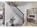Elegant entryway with curved staircase, modern black iron railing, and stylish decor at 19185 Breton Pl, Monument, CO 80132