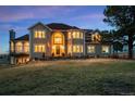 Breathtaking two-story home features a red tile roof, large windows, and lush green lawn at 19185 Breton Pl, Monument, CO 80132